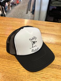 Introducing the Salty Babe Black Ball Trucker hat - the chic way to keep the sun off your face! This classic trucker style hat will have you lookin' cool and keeping the sun out of your eyes all summer long. Keep your style on point with the Salty Babe Black Ball Trucker hat and roll with the punches in fiery fashion! Spring Beach Trucker Hat, 5-panel, Summer Trucker Hat With 5-panel Design, Summer Trucker Hat 5-panel Style, Summer Trucker Hat In 5-panel Style, Summer Trucker Hat 5-panel, Beach-style Trucker Hat With 5-panel Design, Trendy 5-panel Trucker Hat For Beach, Spring Beach Snapback Hat, 5-panel, Lightweight Snapback Summer Hat