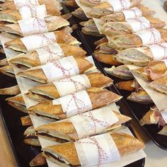 several trays filled with sandwiches on top of each other