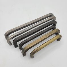 an assortment of metal handles on a white surface