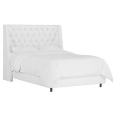 a white bed with tufted headboard and foot board