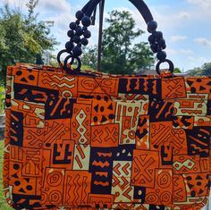 Adametu Collection Quilted Earth Toned Print Ankara Tote Bag . Cool For This Summer Vacation Or A Overnight Stay. Anything Goes ! Made With A Inside Pocket For Your Keys And Cell Phone. 100%Cotton Fabric Trendy Orange Square Shoulder Bag, Orange Tote Shopping Bag, Orange Tote Bag For Shopping, Casual Orange Bags For Daily Use, Trendy Orange Square Satchel, Summer Orange Satchel Shoulder Bag, Orange Square Satchel With Removable Pouch, Orange Satchel Shoulder Bag With Handles, Trendy Orange Rectangular Bag