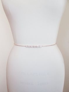 "This sparkly super skinny bridal belt is made with Swarovski crystals beaded on a 1/8\" wide ribbon. The crystal part of the belt measures 26\" long with the center detail measuring 3\" long. Finished with the 1/4\" satin ribbon ties in the back. The entire sash measures 150\" long. Available in gold, silver or rose gold finish. - For the matching headpiece please take a look here: https://www.etsy.com/listing/494798784/swarovski-crystal-hair-vine-rose-gold?ref=shop_home_active_2 - For the phot Elegant Gold Fitted Bridal Belt, Elegant Fitted Gold Bridal Belt, Elegant Gold Waist Chain For Wedding, Elegant Adjustable Chain Belt, Elegant Adjustable Belt For Gift, Elegant Adjustable Belts As Gift, Bridal Jewelry Necklace, Crystal Hair Vine, Bridal Sash Belt