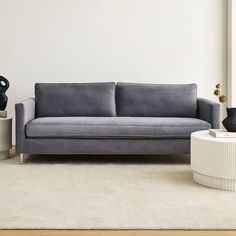 a living room with a gray couch and two vases