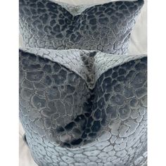 two gray pillows sitting on top of each other