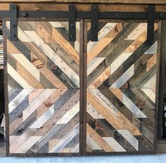 two sliding doors made out of wood with metal bars on each side and an arrow design