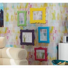 a living room with colorful wallpaper and pictures hanging on the wall, including frames