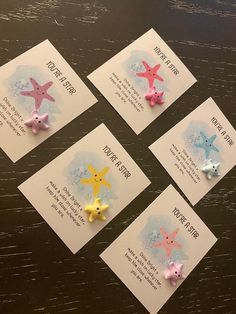 five little starfish pins are on top of some cards