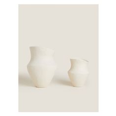 two white vases sitting next to each other