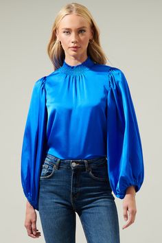 The Figaro blouse flaunts its elegance with a flattering smocked, mock neck. A flowy fit bodice is framed by billowing, balloon sleeves. Wear this calming, satin blouse tucked into high waisted trousers and kitten heels for an effortless, yet sophisticated look.- Smockes mock neck- Balloon sleeves- Keyhole- Chiffon blouse- Comes in 2 colors Size + Fit - Model is 5'8" and wearing size XS- Measurements taken from size S - Chest: 20 1/2"- Length: 24 3/4" Fabric self: 100%polyester Style Number STT1 Black Chiffon Blouse, Satin Blouse, Chiffon Blouse, High Waisted Trousers, Balloon Sleeves, Fitted Bodice, Sweater Weather, Mock Neck, Smocking