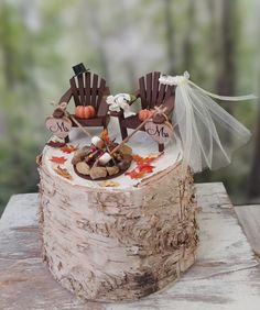 a cake with two chairs on top of it sitting on a wooden table in the woods