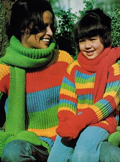 two people sitting next to each other wearing colorful sweaters