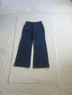 "vintage 1970s jeans Wrangler dark wash denim cotton feel (tag too faded to read) bell bottom leg high waist SCOVILL zipper black bar  1 front left small pocket 2 back pockets 4 wide width (2 1/2\") but skinny height (1 1/2\") belt loops multi-color stitching on pockets/trim good vintage condition, light wear have been hemmed, looks to have at least 1 1/4\" that could be taken out size tag faded out measures, lying flat, waist-15 1/2\" to 16\" w/a tug rise-13 1/2\" hip-22\" inseam-32 1/2\" hem-12\" outseam-44 1/2\"" Dark Wash Full Length Cotton Flares, Full-length Dark Wash Cotton Flares, Full Length Dark Wash Cotton Flares, Retro Denim Blue Flared Denim Pants, Retro High Waist Cotton Flare Jeans, Retro Denim Blue Flares, Full Length Medium Wash Cotton Flares, Retro High Waist Dark Wash Pants, Retro Dark Wash Cotton Flare Jeans