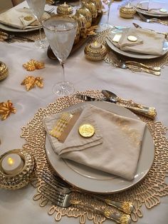 the table is set with silver and gold place settings