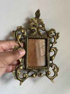 a person is holding up an ornate frame