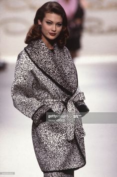 a model walks down the runway wearing a black and white coat with an animal print on it