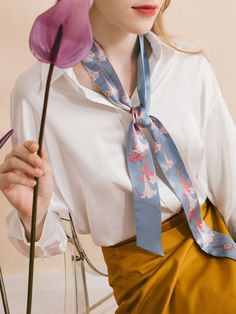 Elevate your wardrobe with the captivating beauty of our "Datura" silk twilly skinny scarf, a stunning accessory inspired by the delicate blooms of the darling darura flower, also known as angel's trumpet. The design embodies the voice of nature, immersing you in its ethereal beauty and transporting you to a realm of tranquility and peace. Made from premium quality silk satin, this skinny scarf is perfect for a hair scarf style. It can also drape elegantly around your neck, immersing you in its Elegant Blue Silk Scarf For Spring, Feminine Silk Scarf As Spring Gift, Feminine Silk Scarf For Spring Gift, Feminine Scarves As Summer Gifts, Feminine Summer Scarves As Gifts, Feminine Summer Scarves As Gift, Spring Gift Neckwear Standard Tie, Spring Gift Standard Neck Tie, Spring Tie Neck Scarf With Ties