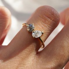 a woman's hand with a diamond ring on top of her finger, showing the side view