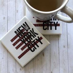 two new york city coasters next to a cup of coffee