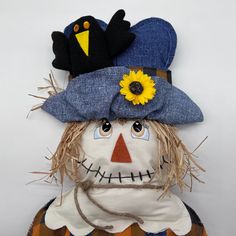 a scarecrow wearing a blue hat with sunflowers on it