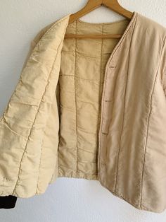 Soft cotton quilted liner jacket in faded peach with brown cuffs. Front buttons. Fabric: Cotton Fit: S Measurements (flat): Armpit to armpit 21 Sleeve 24 Shoulder (across) 17.5 Length (front) 18.25 Length (back) 23 Condition: Excellent Cotton Button-up Outerwear For Daywear, Quilted Beige Cotton Outerwear, Beige Quilted Cotton Outerwear, Cream Cotton Outerwear With Button Cuffs, Long Sleeve Cotton Quilted Jacket With Buttons, Quilted Cotton Jacket With Buttons, Beige Cotton Outerwear With Buttons, Cream Button-up Outerwear For Daywear, Beige Button-up Outerwear For Daywear