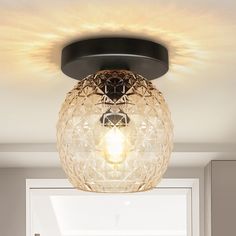 a light that is hanging from the ceiling in a room with white walls and flooring