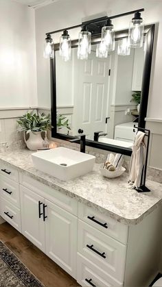 a bathroom with a sink, mirror and lights