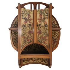 an old wooden clock with floral designs on it's face and back panel, hanging from the wall