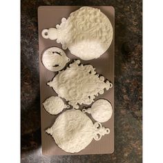 four white frosted cupcakes sitting on top of a cookie sheet in the shape of clouds