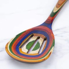 a multicolored wooden spoon sitting on top of a marble counter