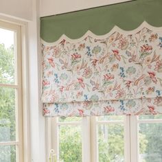 a window with a flowered valance hanging from it's side