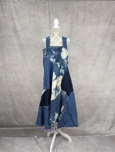 a dress made out of old jeans on a mannequin stand with a gray background