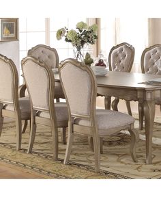 a dining room table and chairs with beige upholstered fabric on the backrests