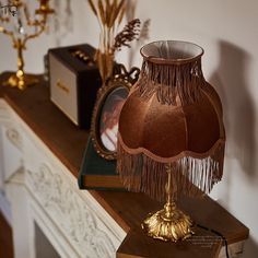 a lamp that is sitting on top of a table next to a clock and other items