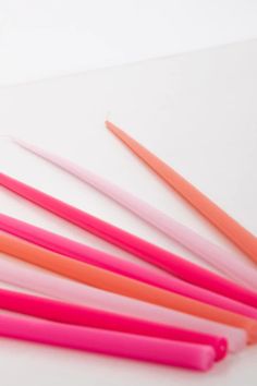 six pink and orange toothbrushes on a white surface