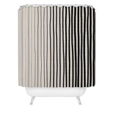 a black and white shower curtain with vertical stripes on the bottom, in front of a white bathtub