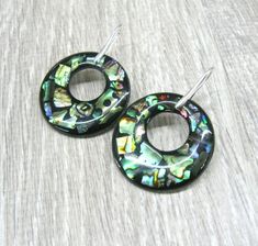 Round abalone paua earrings, Donut earrings, natural shell earrings in sterling silver Rainbow abalone ocean jewelry wide hoop earrings Length: 50 mm from ear hole to the bottom. These earrings are made in mosaic technique out of abalone paua shell pieces in resin. The round charm measures 37 mm in diameter and is 2 mm thick. The hole measures 16 mm in diameter. This shell charm is made of a round piece of white mother of pearl ( see the back side photos ) with rainbow abalone set in resin in fr Handmade Iridescent Round Jewelry, Iridescent Round Jewelry With Ear Wire, Handmade Mother Of Pearl Round Jewelry, Unique Iridescent Round Jewelry, Iridescent Mother Of Pearl Jewelry With Matching Earrings, Unique Nickel-free Mother Of Pearl Jewelry, Pierced Round Mother Of Pearl Jewelry, Nickel-free Round Mother Of Pearl Jewelry, Silver Abalone Shell Drop Earrings