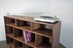 a record player sitting on top of a wooden shelf