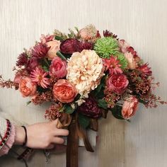 a person holding a bouquet of flowers in their hand