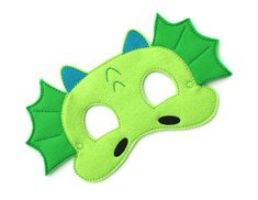 a green dragon mask with black eyes on it's face and one eye closed