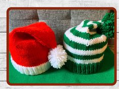 two knitted hats sitting next to each other on top of a green and white blanket