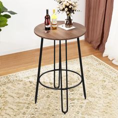 a wooden table with metal legs and a bottle of wine on the side next to it