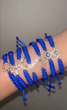 a woman's arm is covered in blue bracelets and beads with evil eyes on them