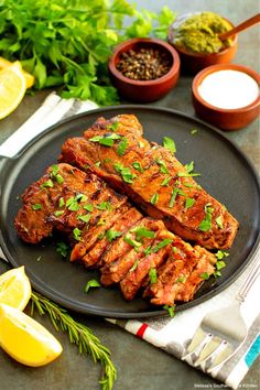 grilled pork chops with herbs on a black plate