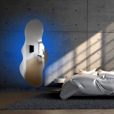 a bed with white sheets and pillows in front of a blue light that is shining on the wall