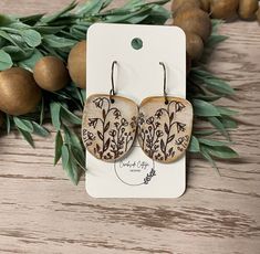 a pair of wooden earrings with floral designs on them