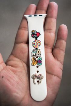 a hand holding a white wii remote control with buttons on it's front and side