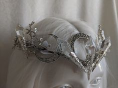 The queen resides in her magical forest and where she reigns, tree branches are made entirely of ice and leaves are made of snow. This unique and beautiful tiara features five clear glass icicles reminiscent of ice, with a triple moon motif decorating the background of the piece. Branches and white leaves surround the piece, creating a gorgeous winter ice queen look. Choose between silver charms as pictured or bronze charms! Choose your crystal color, clear or iridescent! Silver Fantasy Crown Headpiece, Silver Fantasy Wedding Headpiece, Countess Costume, Ice Queen Crown, Ice Accessories, Ice Crown, Ice Queen Costume, Winter Queen, Formal Jewelry