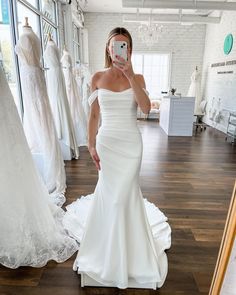 the woman is taking a selfie in her wedding dress