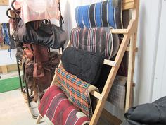 a rack with many different types of cushions and blankets hanging from it's sides