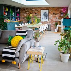 a living room filled with lots of furniture and plants on top of it's tables